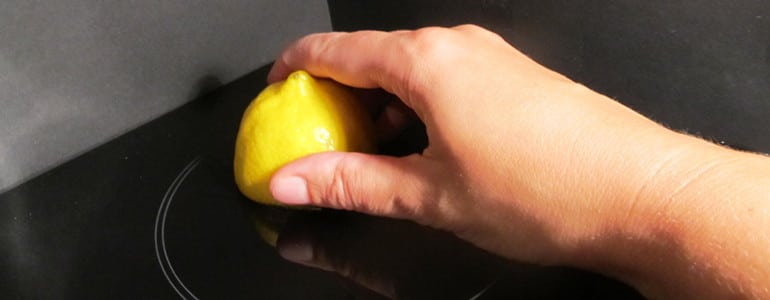 Ceranfeld mit einer Zitronenhaelfte verreiben